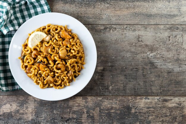 Traditionelle spanische Fideua-Nudelpaella auf Holztisch