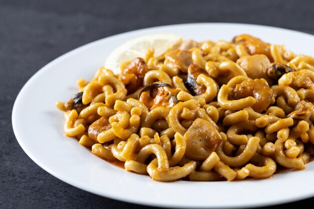 Traditionelle spanische Fideua-Nudelpaella auf schwarzem Hintergrund