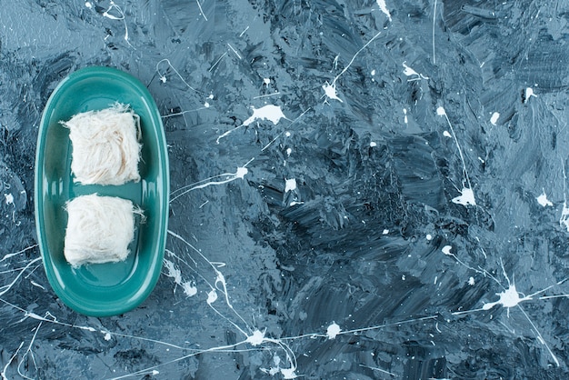 Traditionelle türkische Zuckerwatte auf einem Teller auf dem blauen Tisch.