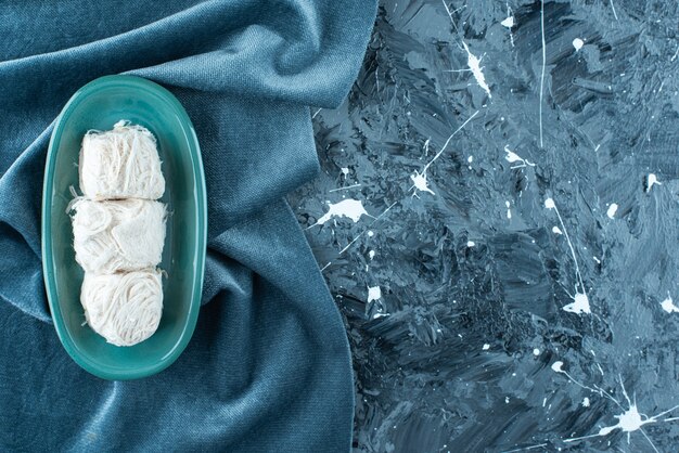 Traditionelle türkische Zuckerwatte auf einem Teller auf einem Handtuch auf dem blauen Tisch.