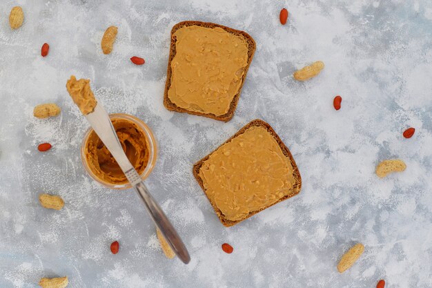 Traditionelles amerikanisches und europäisches Sommerfrühstück: Sandwiche des Toasts mit Erdnussbutter, Draufsicht der Kopie