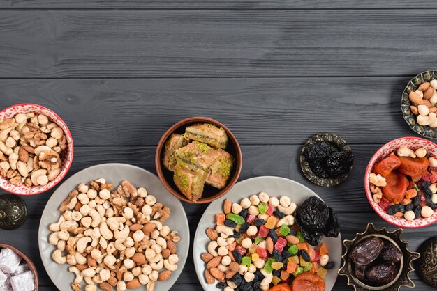 Traditionelles arabisches Ramadan-Baklava; Trockenfrüchte und Nüsse auf Holztisch gedient
