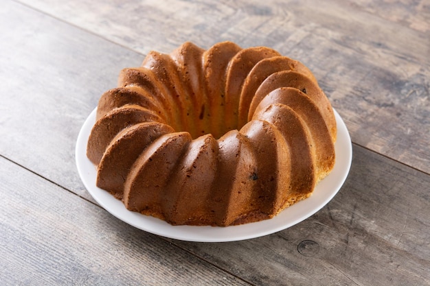 Traditionelles Bundt-Kuchenstück mit Rosinen auf Holztisch