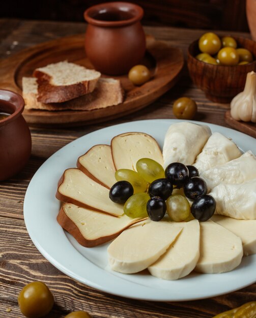 Traditionelles Setup für Käseplatte mit geräuchertem, weißem Ziegenkäse, Trauben