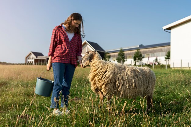 Kostenloses Foto tragender eimer der vollen schussfrau