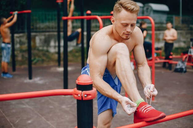 Training des gutaussehenden Mannes in einem Sommerpark