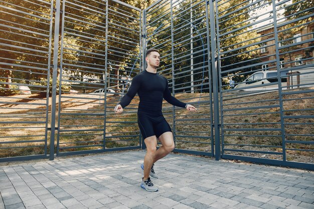 Training des gutaussehenden Mannes in einem Sommerpark