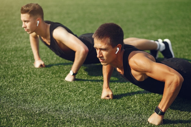 Training des gutaussehenden Mannes in einem Sommerpark