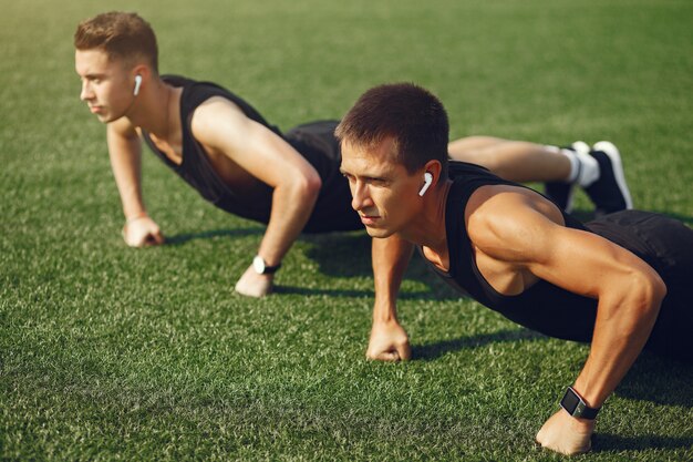 Training des gutaussehenden Mannes in einem Sommerpark