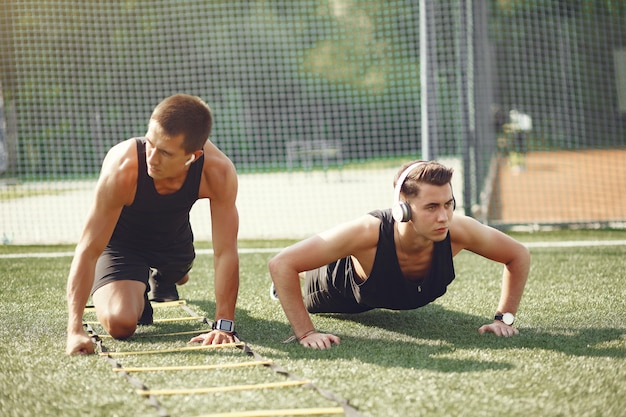 Training des gutaussehenden Mannes in einem Sommerpark