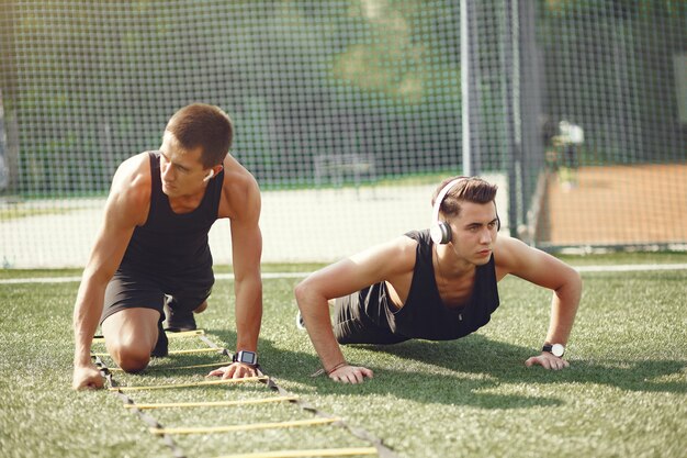 Training des gutaussehenden Mannes in einem Sommerpark