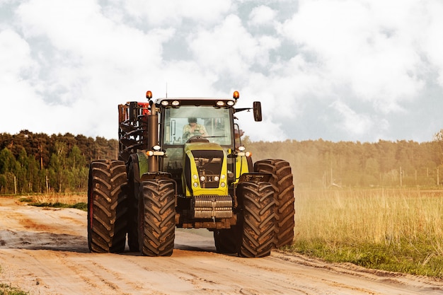 Traktor auf einer Straße an der Landschaft nahe Wiesen