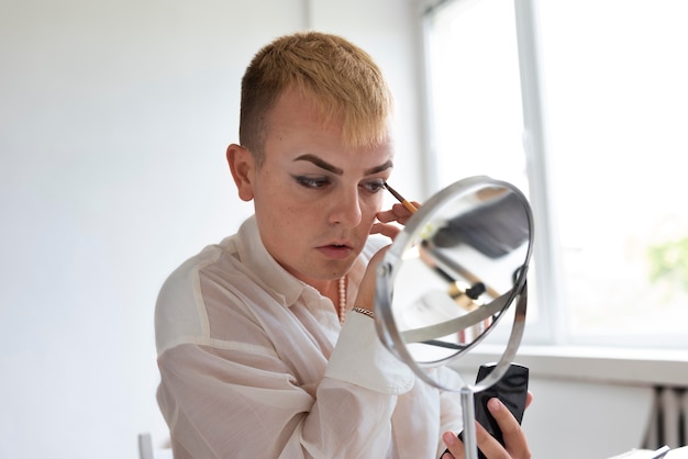 Transgender mit Make-up-Pinsel Nahaufnahme