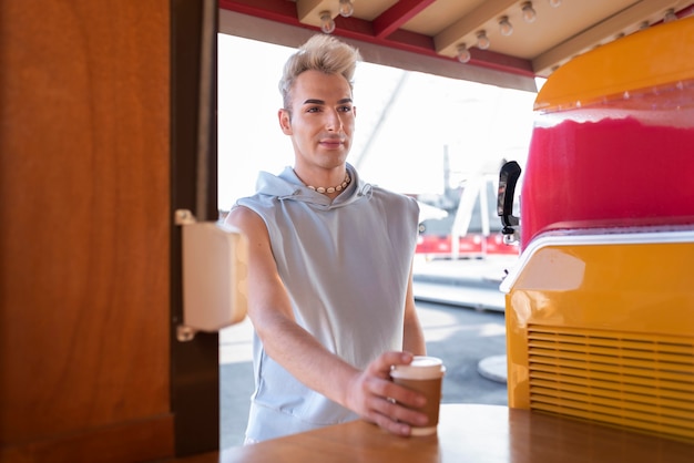 Kostenloses Foto transgender mit mittlerer aufnahme, der kaffeetasse hält