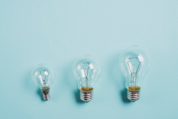 Transparente Glühlampe auf blauem Hintergrund aufwachsen