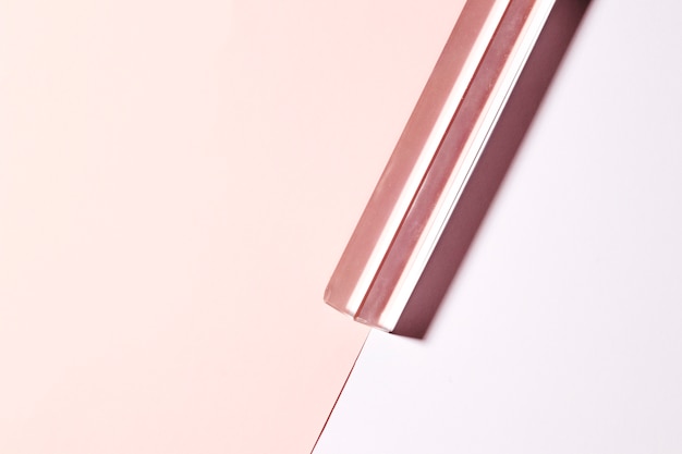 Transparenter langer Kristall auf doppeltem rosa Hintergrund