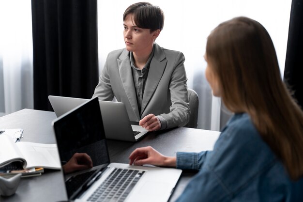 Transperson, die mit Kollegen im Büro arbeitet