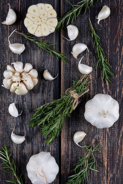 Trauben Rosmarin Knoblauch auf einem dunklen Holztisch. Seitenansicht.