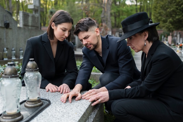 Trauernde Familie gemeinsam auf dem Friedhof