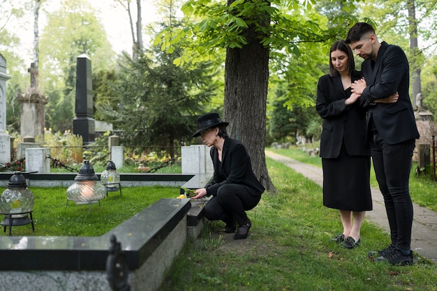 Trauernde Familie gemeinsam auf dem Friedhof