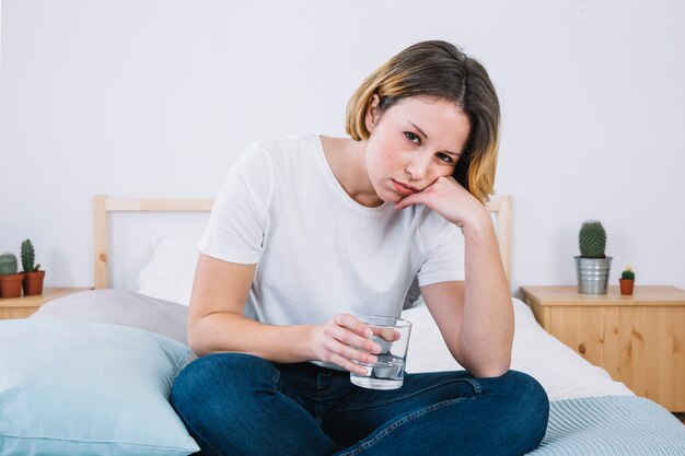 Traurige Frau mit dem Wasser, das Kamera betrachtet