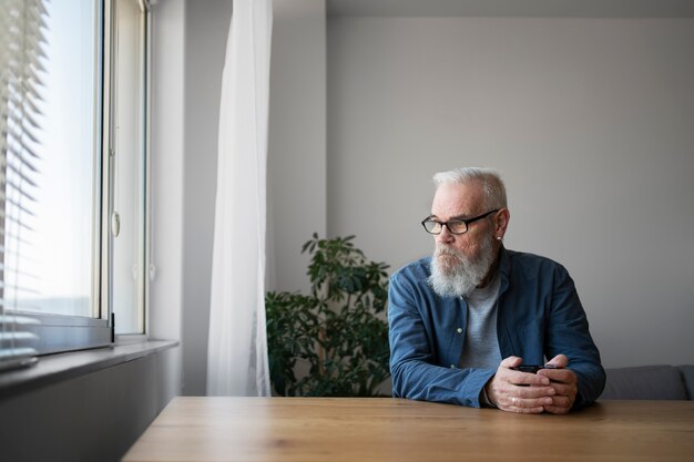 Kostenloses Foto trauriger älterer mann zu hause