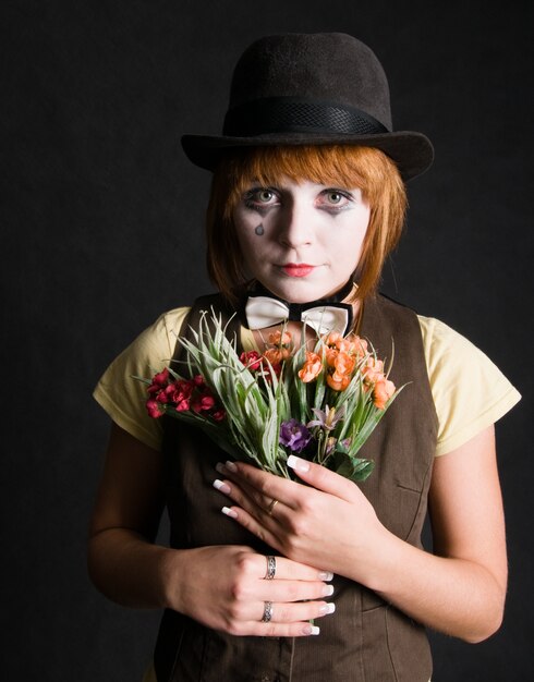 Trauriger Clown mit Blumen