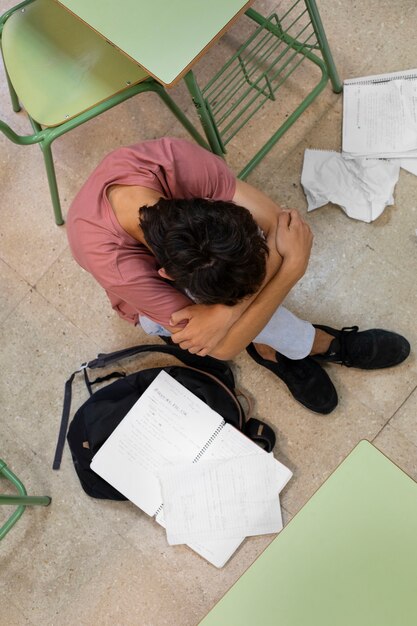 Trauriger Junge der Draufsicht im Klassenzimmer