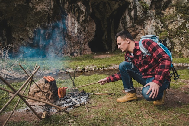 Traveller, der Wurst im Freien vorbereitet