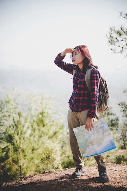 Traveller Mädchen suchen rechts Richtung auf Karte, während der Reise zum Wandern in den Bergen. Reisekonzept