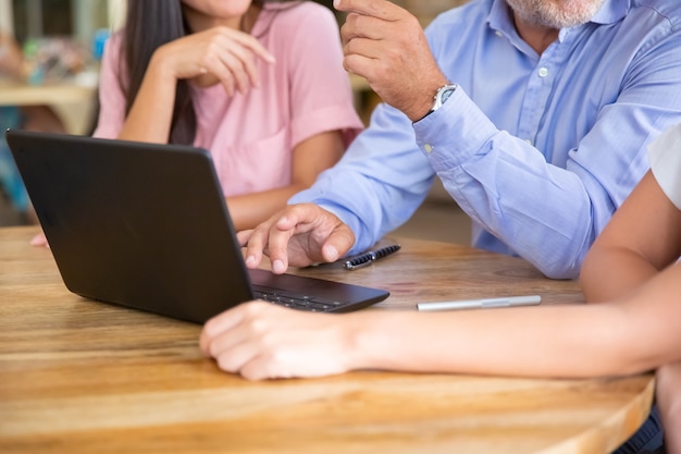 Treffen des Geschäftsteams am offenen Laptop, Präsentation ansehen, sprechen, diskutieren und Ideen austauschen