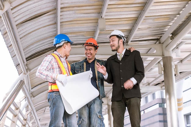 Treffen des Managers mit dem Ingenieur am Standort im Freien besprechen den Plan mit der Blaupause