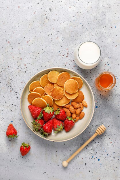 Trendy Food - Mini-Pfannkuchen-Müsli. Haufen Getreidepfannkuchen mit Beeren und Nüssen.