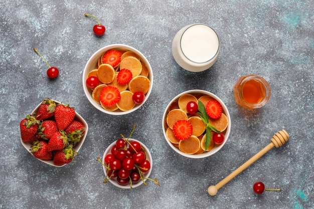 Trendy Food - Mini-Pfannkuchen-Müsli. Haufen Getreidepfannkuchen mit Beeren