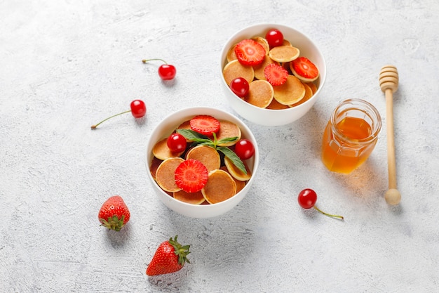 Trendy Food - Mini-Pfannkuchen-Müsli. Haufen Getreidepfannkuchen mit Beeren