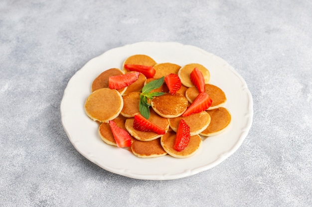 Trendy Food - Mini-Pfannkuchen-Müsli. Haufen Müsli-Pfannkuchen mit Beeren und Nüssen.