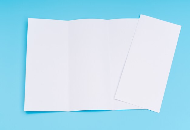 Trifold weiße Vorlage Papier auf blauem Hintergrund.