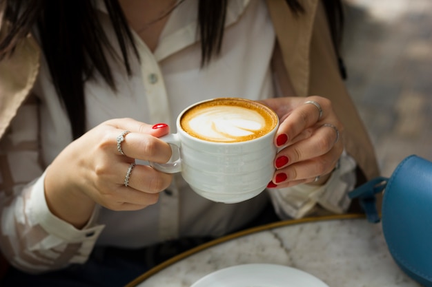 Trinkende Cappuccinotasse der Frau