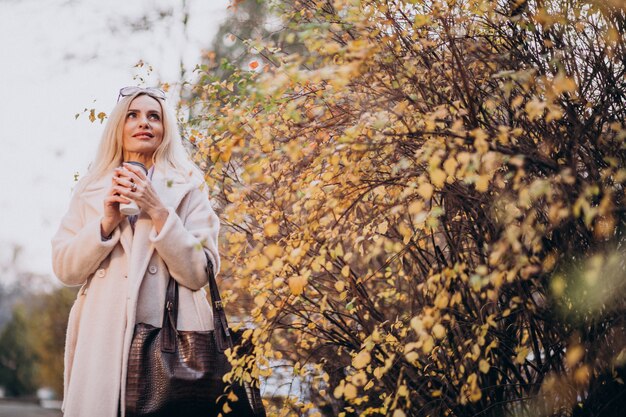 Trinkender Kaffee der älteren Frau außerhalb des Herbstparks