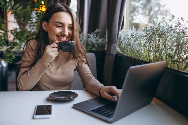 Trinkender Kaffee der Geschäftsfrau und Arbeiten an Laptop in einem Café