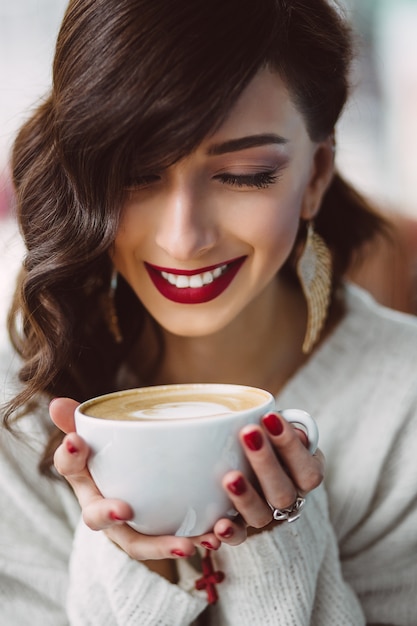 Trinkender Kaffee des jungen Mädchens in einem modischen Café