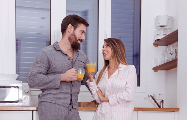 Trinkender Saft der jungen Paare in der Küche