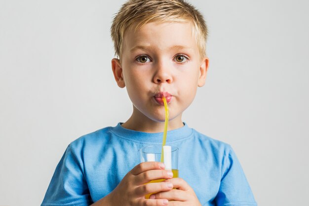 Trinkender Saft des Nahaufnahmejungen