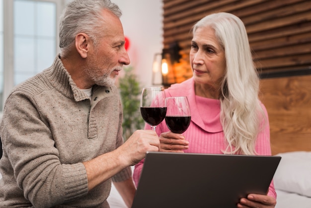 Trinkender Wein der älteren Paare mit Modell