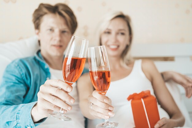 Trinkender Wein des glücklichen Paars im Schlafzimmer