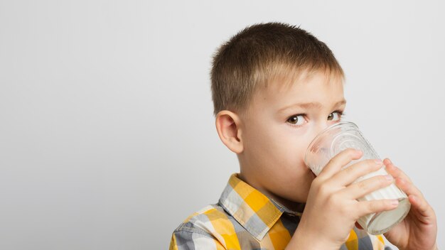 Trinkmilch des Jungen mit Glas