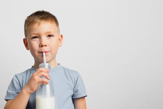 Trinkmilch des Jungen mit Strohhalm