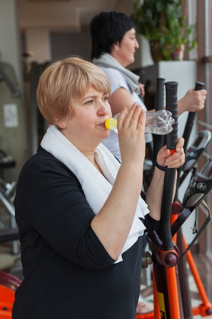 Kostenloses Foto trinkwasser der frau der seitenansicht