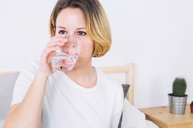 Kostenloses Foto trinkwasser der frau im schlafzimmer