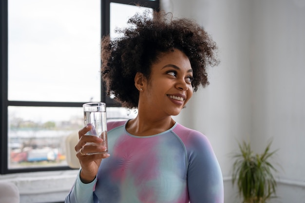 Kostenloses Foto trinkwasser der passenden frau des mittleren schusses